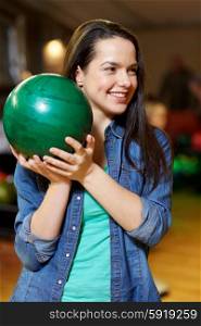 people, leisure, sport and entertainment concept - happy young woman holding ball in bowling club