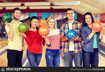 people, leisure, sport, friendship and entertainment concept - happy friends in bowling club