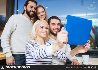people, leisure, technology and friendship concept - happy friends with tablet pc computer taking selfie at cafe