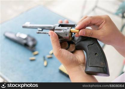 people load bullets into revolver gun befor shooting