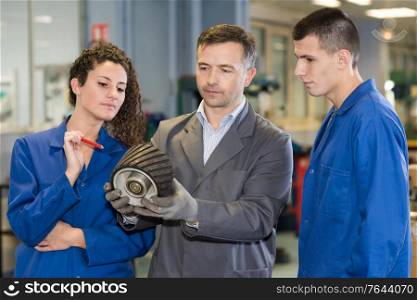 People looking at mechanical part