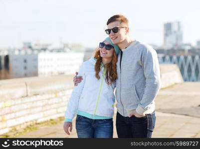 people, love and friendship concept - happy teenage couple walking in city