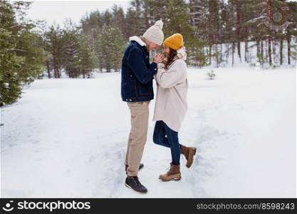 people, love and leisure concept - happy man warming woman&rsquo;s hands in winter park. happy man warming woman&rsquo;s hands in winter park