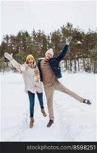 people, love and leisure concept - happy smiling couple having fun in winter park. happy smiling couple having fun in winter park