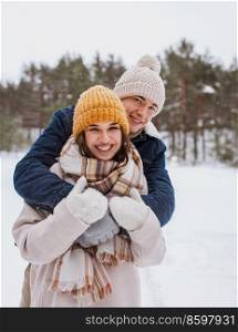 people, love and leisure concept - happy smiling couple hugging in winter park. happy smiling couple hugging in winter park