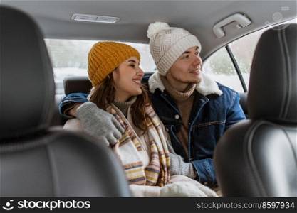 people, love and leisure concept - happy smiling couple hugging on car back seat in winter. happy smiling couple on car back seat in winter