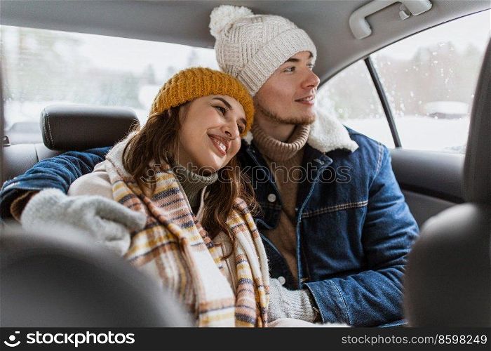 people, love and leisure concept - happy smiling couple hugging on car back seat in winter. happy smiling couple on car back seat in winter