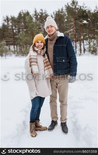 people, love and leisure concept - happy smiling couple in winter park. happy smiling couple in winter park