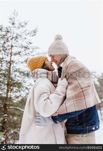 people, love and leisure concept - happy smiling couple touching noses in winter park. happy smiling couple touching noses in winter