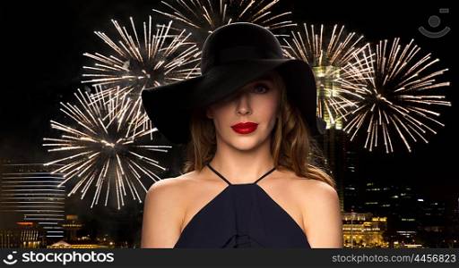 people, luxury and fashion concept - beautiful woman in black hat over night singapore city and firework background