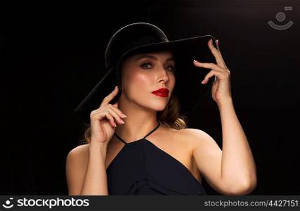 people, luxury and fashion concept - beautiful woman in black hat over dark background
