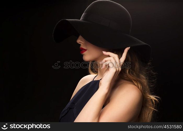 people, luxury and fashion concept - beautiful woman in black hat over dark background