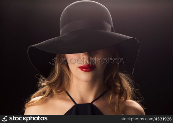 people, luxury and fashion concept - beautiful woman in black hat over dark background