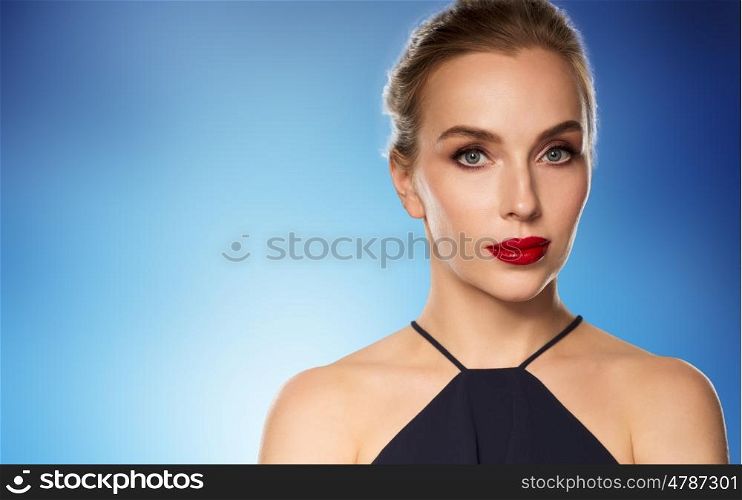 people, luxury and fashion concept - beautiful woman in black with red lips over blue background