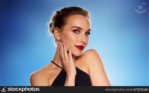 people, luxury and fashion concept - beautiful woman in black with red lips over blue background