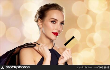 people, luxury and sale concept - beautiful woman with credit card and shopping bags