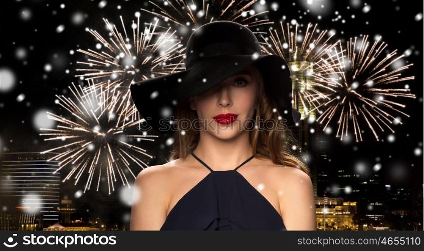 people, luxury, christmas, new year and winter holidays concept - beautiful woman in black hat over night singapore city and firework background with snow
