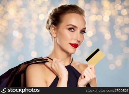 people, luxury, holidays and sale concept - beautiful woman with credit card and shopping bags over lights background