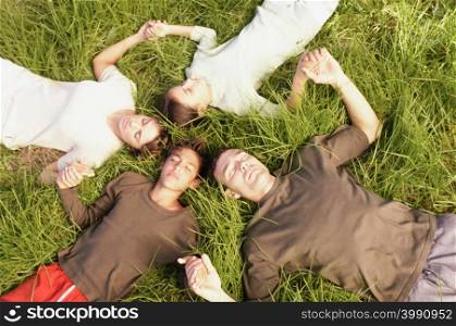 People lying in circle on grass
