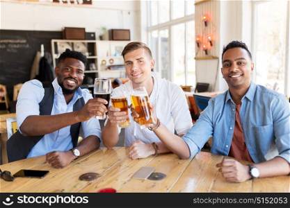 people, male friendship and celebration concept - happy friends drinking beer and clinking glasses at bar or pub. happy male friends drinking beer at bar or pub
