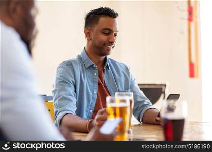 people, male friendship and communication concept - happy friends drinking beer at bar or pub. happy male friends drinking beer at bar or pub