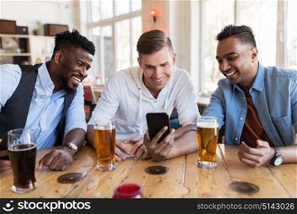 people, male friendship and technology concept - happy friends with smartphone drinking beer at bar or pub. male friends with smartphone drinking beer at bar