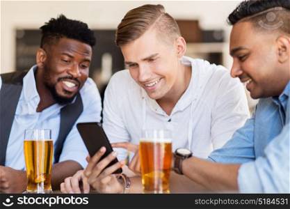 people, male friendship and technology concept - happy friends with smartphone drinking beer at bar or pub. male friends with smartphone drinking beer at bar