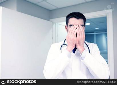 people, medicine, healthcare and sorrow concept - sad or crying male doctor at hospital ward. sad or crying male doctor at hospital ward