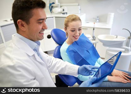 people, medicine, stomatology and health care concept - happy male dentist showing tablet pc computer to woman patient at dental clinic office