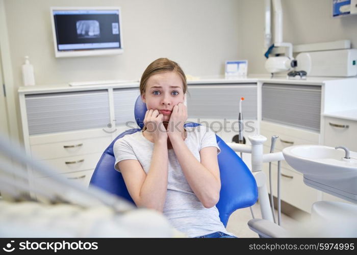 people, medicine, stomatology and phobia concept - scared and terrified patient girl at dental clinic office