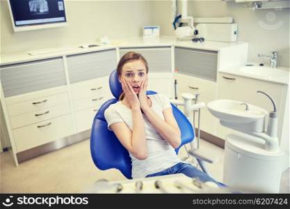 people, medicine, stomatology and phobia concept - scared and terrified patient girl at dental clinic office