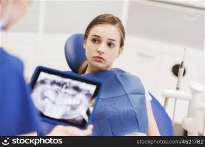 people, medicine, stomatology, technology and health care concept - dentist with x-ray on tablet pc computer and girl patient