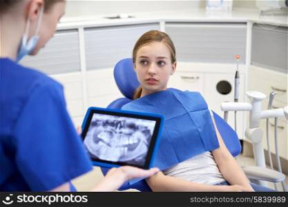 people, medicine, stomatology, technology and health care concept - female dentist showing teeth x-ray on tablet pc computer to patient girl at dental clinic office