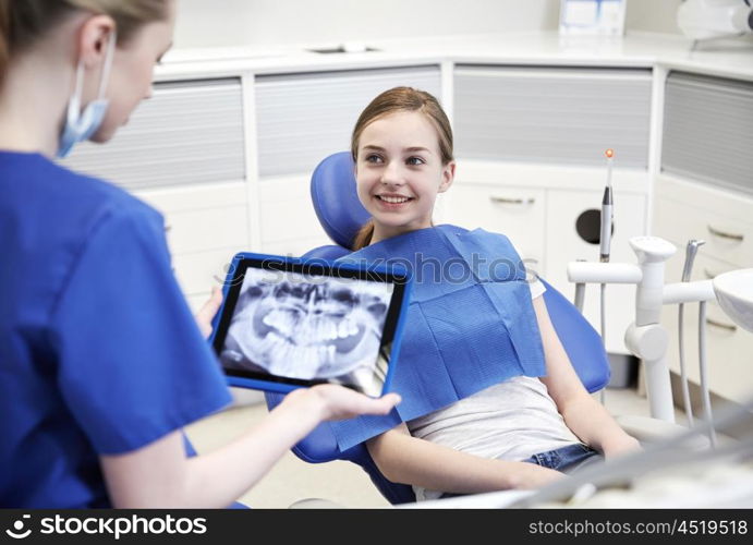 people, medicine, stomatology, technology and health care concept - happy female dentist with teeth x-ray on tablet pc computer and patient girl at dental clinic office