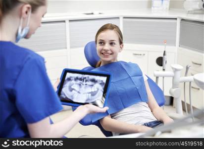people, medicine, stomatology, technology and health care concept - happy female dentist with teeth x-ray on tablet pc computer and patient girl at dental clinic office