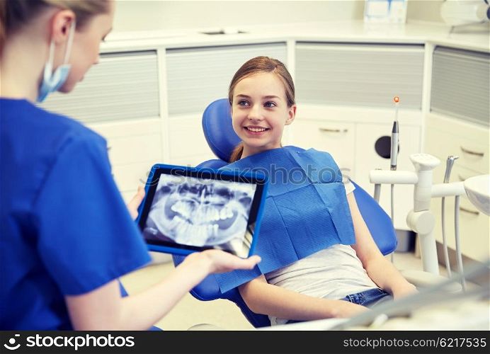 people, medicine, stomatology, technology and health care concept - happy female dentist with teeth x-ray on tablet pc computer and patient girl at dental clinic office