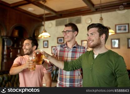 people, men, leisure, friendship and celebration concept - happy male friends clinking beer glasses and watching sport game or football match at bar or pub