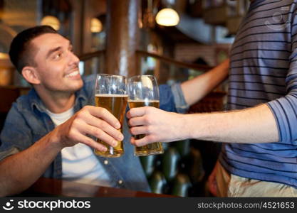 people, men, leisure, friendship and celebration concept - happy male friends drinking beer and clinking glasses at bar or pub