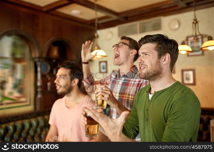 people, men, leisure, friendship and celebration concept - male friends or fans watching sport game or football match at bar or pub