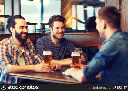 people, men, leisure, friendship and communication concept - happy male friends drinking beer at bar or pub