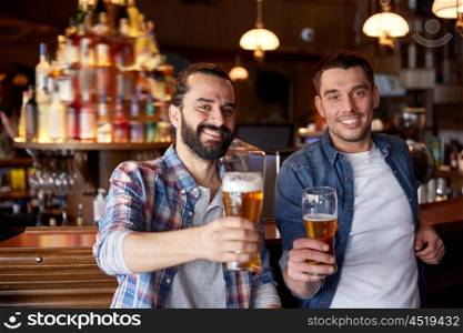 people, men, leisure, friendship and party concept - happy male friends drinking draft beer at bar or pub