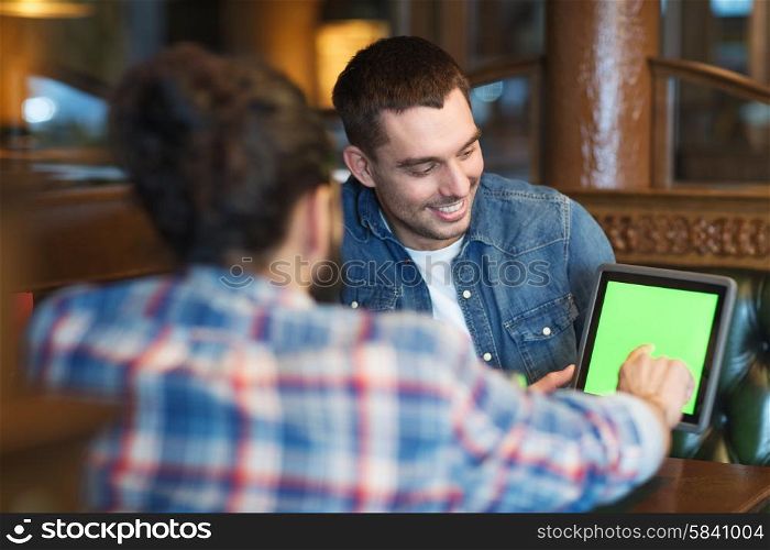 people, men, leisure, friendship and technology concept - happy male friends with tablet pc computer at bar or pub