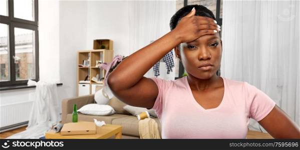 people, mess and stress concept - stressed african american woman suffering from headache or fever over dirty room background. stressed african american woman over dirty room