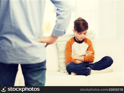 people, misbehavior, family and relations concept - close up of upset or feeling guilty boy and father at home. upset or feeling guilty boy and father at home
