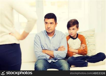 people, misbehavior, family and relations concept - upset feeling guilty or displeased father, son and angry mother at home. upset or displeased father, son and mother at home