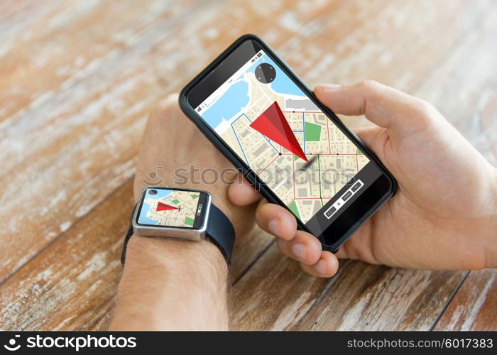 people, modern technology, application and navigation concept - close up of male hand holding smart phone and wearing watch with gps and road map on screen