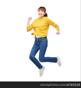 people, motion and action concept - happy asian young woman jumping over white