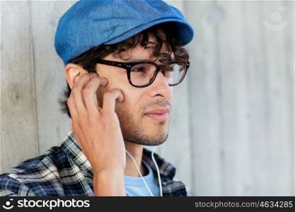 people, music, leisure and lifestyle - close up of man with earphones listening to music on street