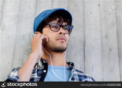 people, music, leisure and lifestyle - man with earphones listening to music on street