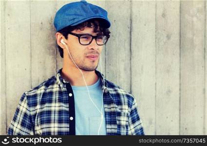 people, music, leisure and lifestyle - man with earphones listening to music on street. man with earphones listening to music on street